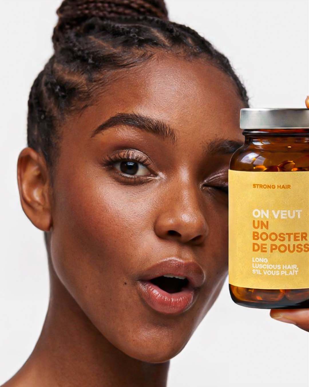 Atelier Nubio Long Luscious Hair, S'il Vous Plait model holding the jar of capsules beside her face