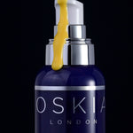 Oskia Midnight Elixir serum texture dripping over the bottle