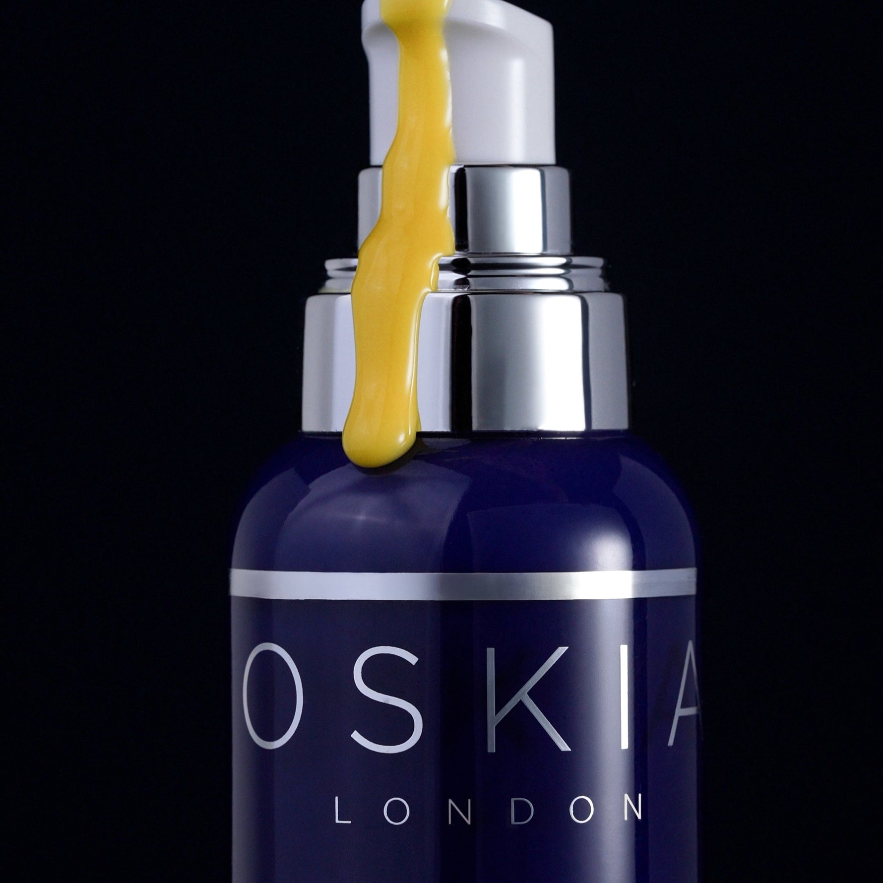 Oskia Midnight Elixir serum texture dripping over the bottle