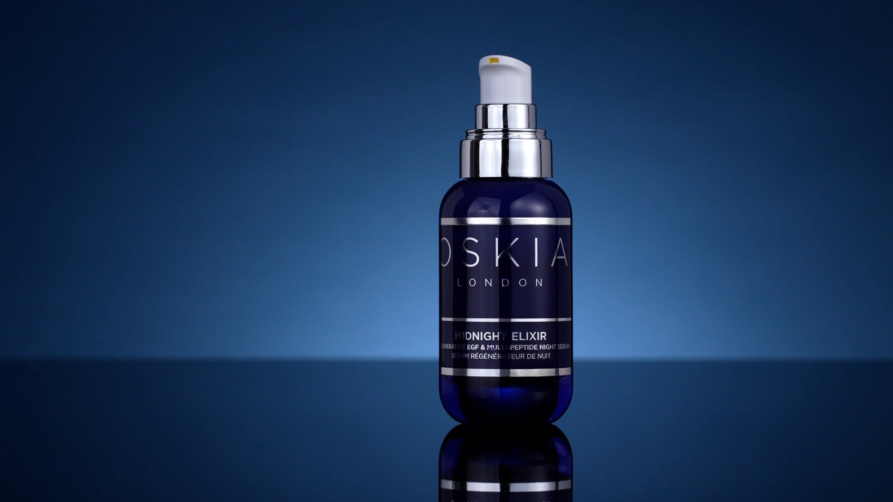 OSKIA Midnight Elixir night serum on a deep blue background