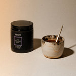 WelleCo The Evening Elixir jar beside a ceramic cup of hot chocolate with a gold spoon